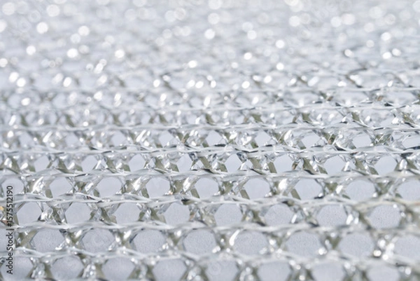 Obraz Close-up of intricate mesh pattern of a dishwashing sponge, emphasizing its reflective and high-quality industrial appearance. Photo. High resolution.