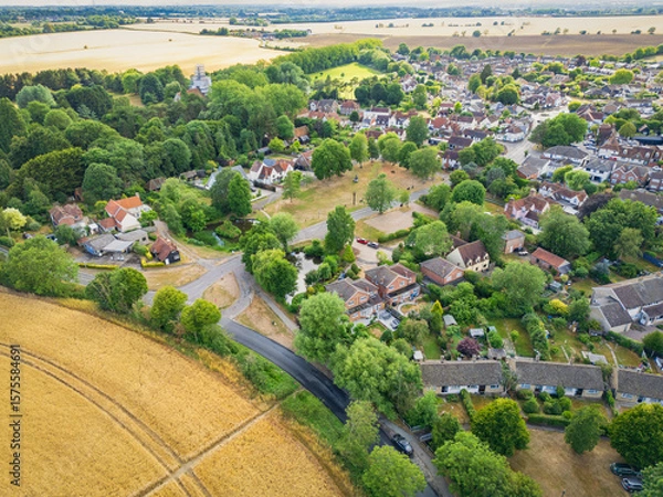 Fototapeta Large English village in rural Essex en surrounded by drought ridden arable fields in summer. A parched village green can be seen near the centre of the photograph.