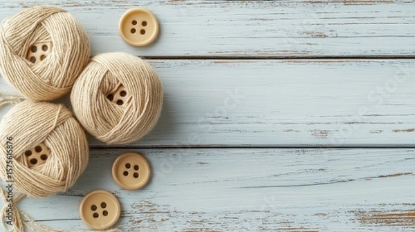 Fototapeta Sustainable fashion concept Soft yarn balls and wooden buttons are arranged on a rustic wooden background, creating a cozy crafting scene.