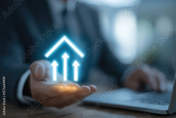 Fototapeta Businessman's hand holding glowing upward-pointing arrows forming a house shape