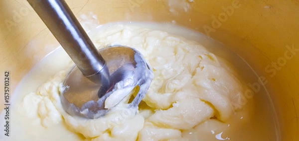 Obraz Whipping cream and butter cream with a mixer or blender, preparing cream filling. Mixing butter and cream.