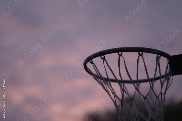Obraz Basketball hoop silhouetted against nostalgic dusk sky
