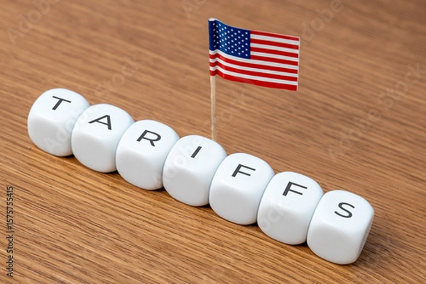 Obraz Cubes spelling "TARIFFS" are arranged in a line with a small American flag. Concept of tariffs, particularly in relation to the United States.