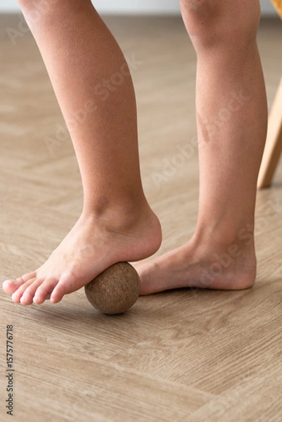 Obraz prevention of flat feet, close-up of child's feet with massage ball, orthopedic exercises