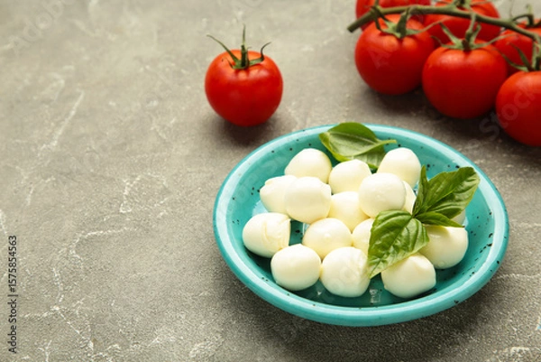 Obraz Italian Caprese salad with cherry tomatoes, mozzarella, basil on plate on grey concrete background.