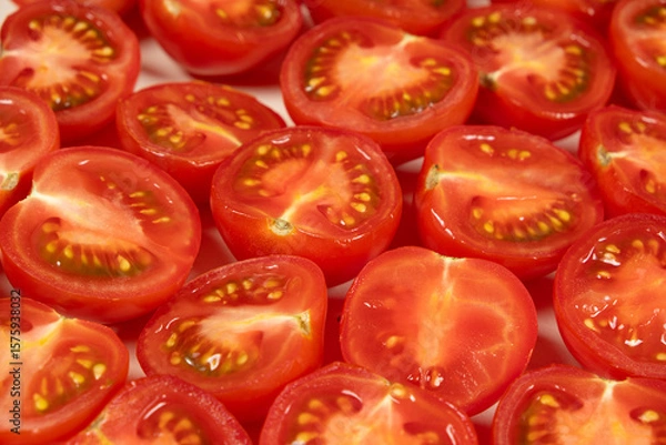 Fototapeta Close-Up of Fresh Cut Small Tomatoes. Vibrant Red Culinary Background.