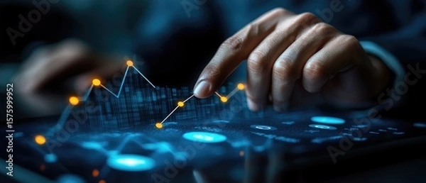 Fototapeta Person interacts with digital financial data displayed on a tablet.