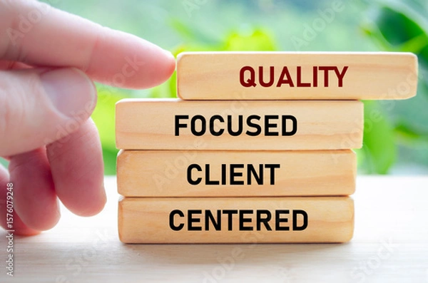 Fototapeta Quality focused client centered text on wooden blocks held by hand showcases a dedication to understanding and serving clients