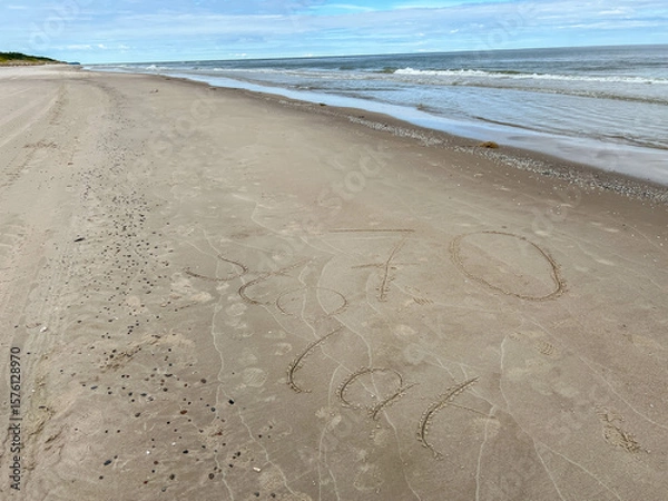 Fototapeta Sand on the Baltic Sea beach in Mrzezyno in Poland after being washed by a wave in close-up as a background