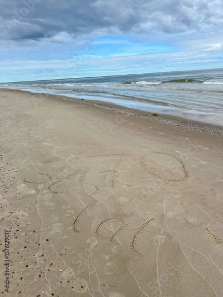 Fototapeta Sand on the Baltic Sea beach in Mrzezyno in Poland after being washed by a wave in close-up as a background