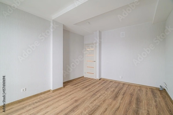 Obraz bright, empty room with wood-like flooring, white walls, and a white door with horizontal glass panes, creating a clean and minimalist aesthetic