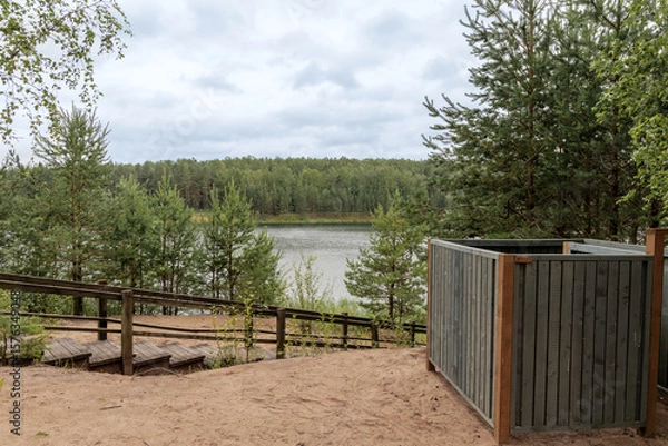 Fototapeta Latvian lake landscape with wooden stairs and pine forest