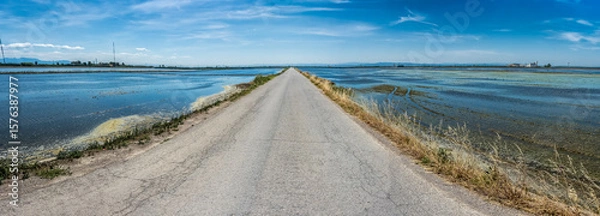 Obraz Asphalt road that disappears into infinity between two sheets of water
