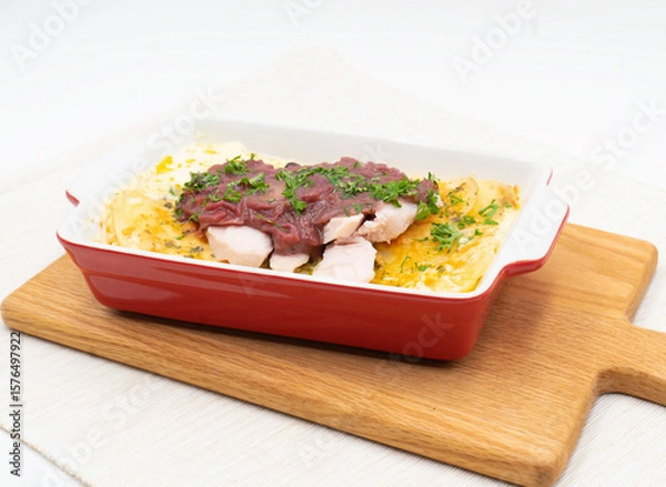 Fototapeta Delicious Potato Gratin with Red Onion Relish Turkey style topped with tender chunks in Baking Dish on white background side view