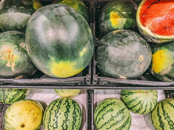 Fototapeta A bunch of watermelons are displayed in a store