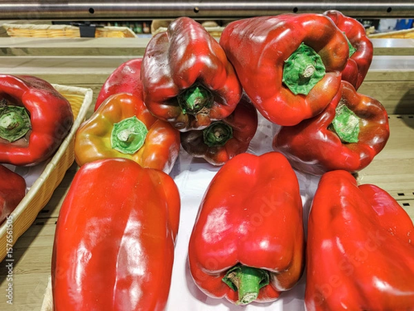 Fototapeta A bunch of red bell peppers are displayed on a table