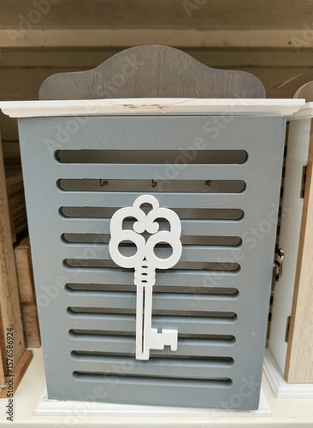 Fototapeta A gray and white key holder with a key on it
