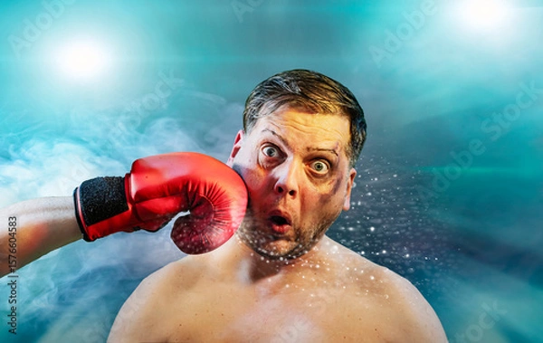 Fototapeta Shocked man getting punched by red boxing glove getting hit in face  with dramatic impact