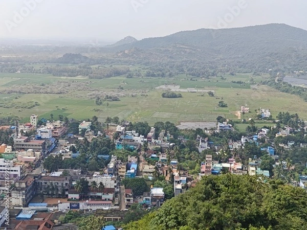 Fototapeta A spiritually resonant view of Thirukazhukundram, Tamil Nadu, India, capturing both the hilltop Vedagiriswarar Temple and the ancient foothill temple complex. The hill temple, dedicated to Lord Shiva,