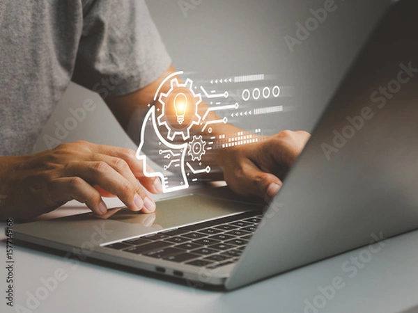 Fototapeta Person typing on laptop keyboard with digital light bulb and gear icon representing innovation and technology concept