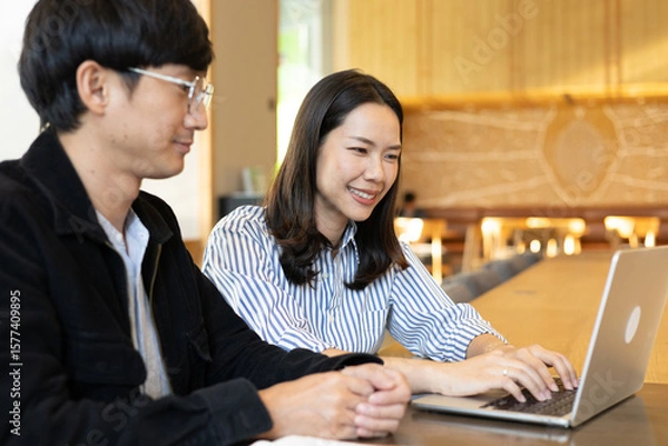 Fototapeta close up businesswoman work on laptop and talk or consult about new marketing plan project with businessman for business advice and team concept