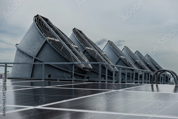 Fototapeta Cooling fans are installed on rooftop of large commercial building. Maintaining air circulation and temperature control. Tower air chiller HVAC.