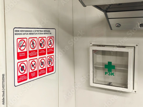 Obraz emergency exit sign, A safety and hygiene reminder poster is displayed next to a first aid (P3K) box inside a public facility. The sign lists prohibited activities to ensure cleanliness, order, and co