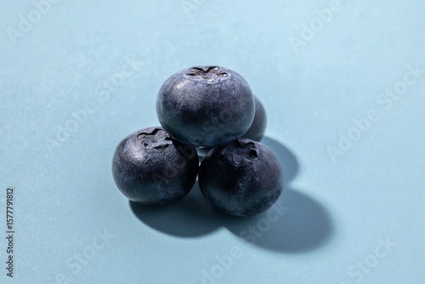Obraz Three Blueberries Closeup on a Light Blue Background