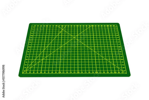 Fototapeta Small green cutting mat with yellow grid and angle markings is isolated.