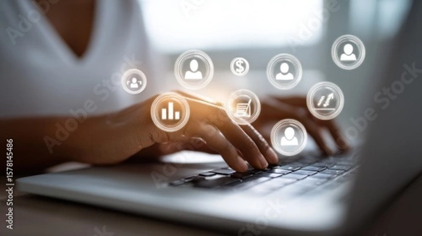 Fototapeta Hands typing on laptop with digital business icons