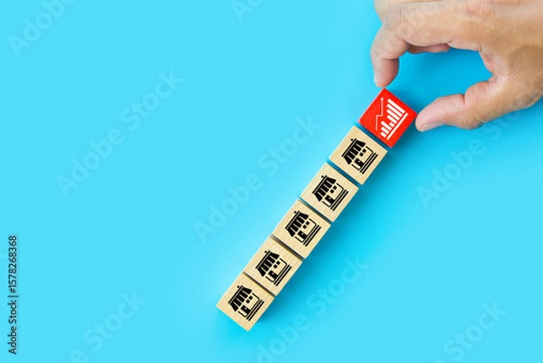 Fototapeta Hand choose wooden block stack with graph and franchise icon for goal to growth is investment planning financial and branch expansion and management bank loans or marketing franchising business.