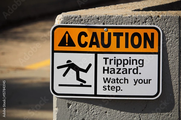 Fototapeta Caution tripping hazard sign on a wall