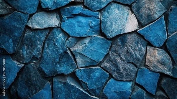 Fototapeta Close-up view of a wall made of textured, irregular, blue stones.