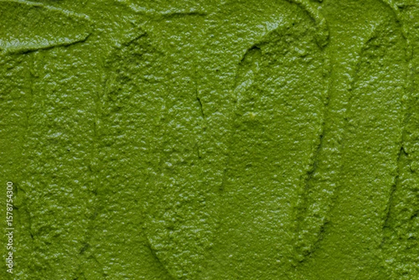 Obraz Arugula pesto made of arugula leaves, walnuts, parmesan, garlic, and olive oil, prepared for freezing. Background texture.