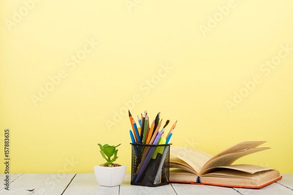 Fototapeta education and wisdom concept - open book on wooden table, color background