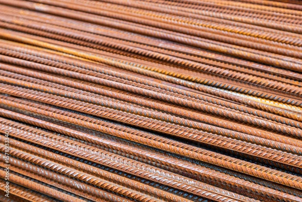 Fototapeta Rusty steel rebar rods arranged in parallel lines at construction site