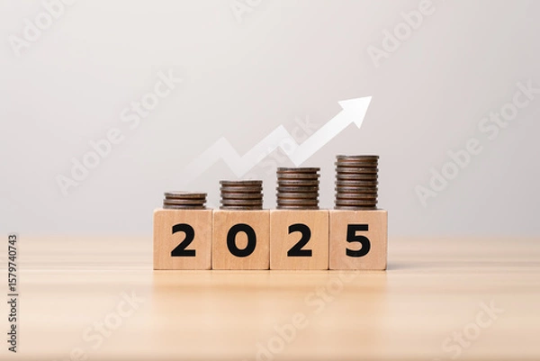 Obraz Saving money and financial planning in 2025 with increasing stacked coins on wooden blocks and rising arrow graph symbolizing investment growth, business success, wealth management and economic goals