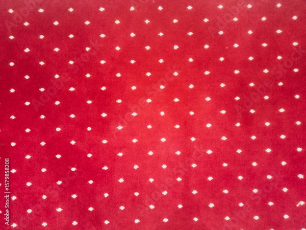 Fototapeta The texture of the red carpet with a white dot motif neatly arranged in a straight line gives an elegant impression as a background for industrial product catalog design.