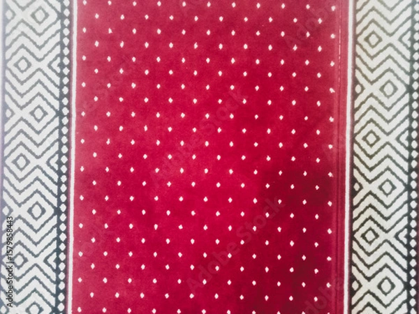Fototapeta The texture of the red carpet with a white dot motif neatly arranged in a straight line gives an elegant impression as a background for industrial product catalog design.