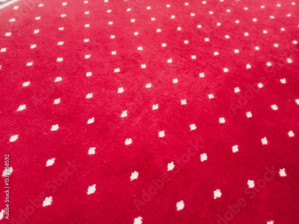 Fototapeta The texture of the red carpet with a white dot motif neatly arranged in a straight line gives an elegant impression as a background for industrial product catalog design.