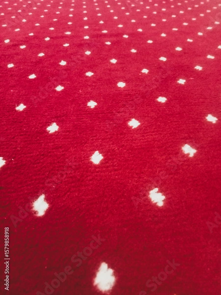 Fototapeta The texture of the red carpet with a white dot motif neatly arranged in a straight line gives an elegant impression as a background for industrial product catalog design.