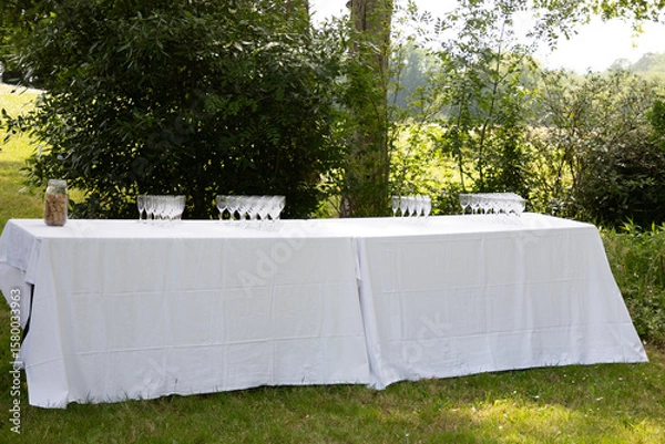Fototapeta festive table setting with empty glasses for coktail outdoors banquet on terrace restaurant in garden nature