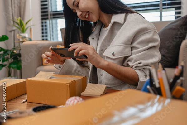 Fototapeta she in an entrepreneur, she sells product online, she own a small business that sell product online, sme, a lot of parcel stack in the room, working in her shopping online storage