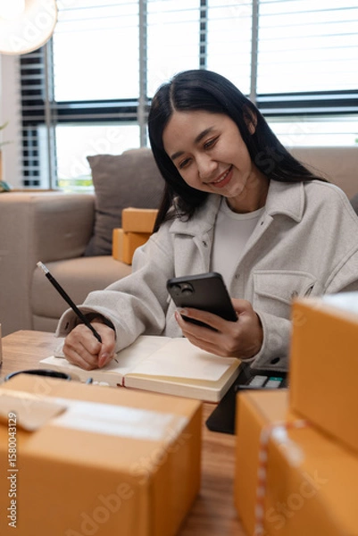 Fototapeta she in an entrepreneur, she sells product online, she own a small business that sell product online, sme, a lot of parcel stack in the room, working in her shopping online storage