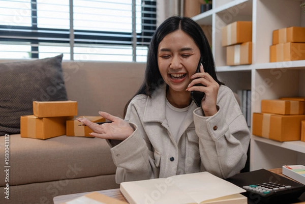 Fototapeta this businesswoman own a small business, sme, she is working in online business to sell her product, a lot of parcel, package, an entrepreneur is working on the parcel before deliver to customer