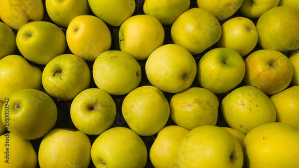 Fototapeta background yellow green apples in a market for sale