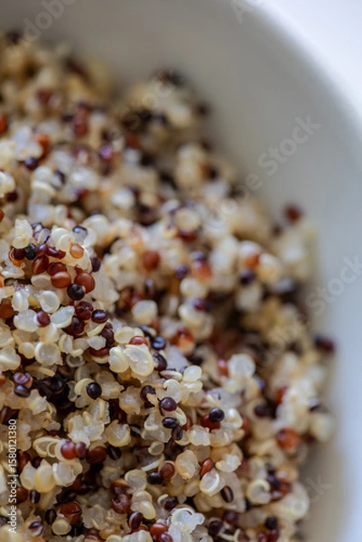 Fototapeta Macro image of freshly cooked tricolor quinoa with white, red, and black seeds in a white bowl. Healthy, gluten-free superfood rich in protein and texture.