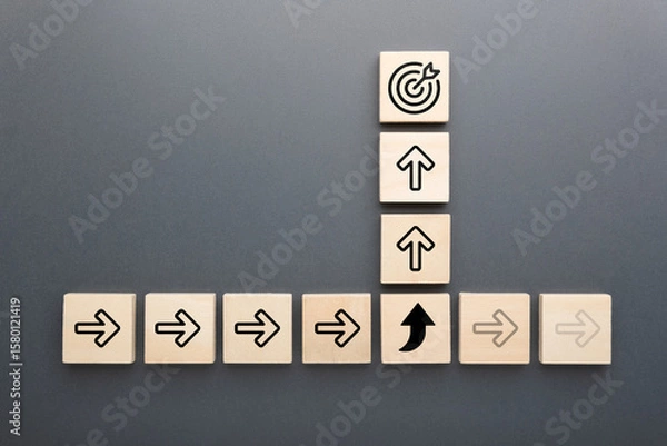 Obraz Wooden blocks with arrow icons and target symbol show concept of changing direction, adapting strategy, and focusing on goals for success and growth