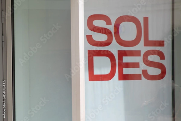 Fototapeta sale means soldes in french text red sign on windows storefront