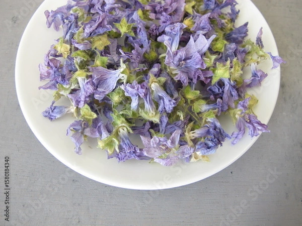 Obraz Dried mallow flowers on a small plate